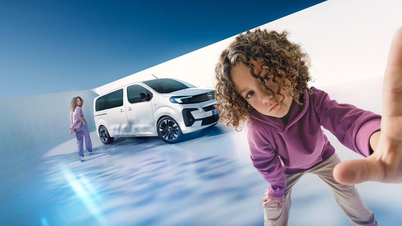  Kind greift nach vorn, weißer Van Opel Zafira Electric und Frau im Hintergrund.